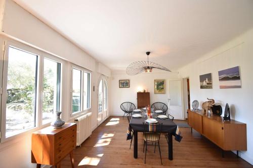 d'une salle à manger avec une table et quelques fenêtres. dans l'établissement Ourika - Hossegor belle villa située proche du lac marin du centre ville et du stade, à Soorts-Hossegor