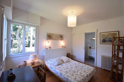 une chambre avec un lit, une table et une fenêtre dans l'établissement Ourika - Hossegor belle villa située proche du lac marin du centre ville et du stade, à Soorts-Hossegor