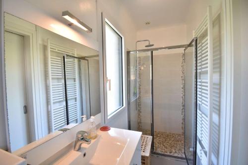 une salle de bain avec un lavabo, une douche et un miroir dans l'établissement Ourika - Hossegor belle villa située proche du lac marin du centre ville et du stade, à Soorts-Hossegor