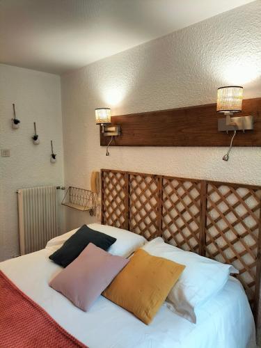 a bed with two pillows on top of it at Logis HOTEL RESTAURANT La Régence in Cherbourg en Cotentin