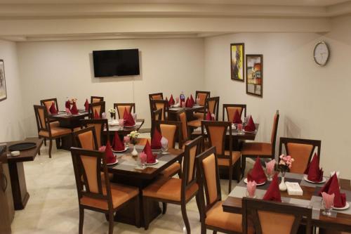 a restaurant with tables and chairs with red napkins on them at S Chalet Islamabad in Islamabad
