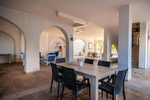 a dining room and living room with a table and chairs at Villa Gaudì - Pedrera in Sant'Isidoro