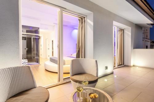 a living room with a table and chairs and a view of a bedroom at Hibrido Boutique Hotel & Spa in Sciacca
