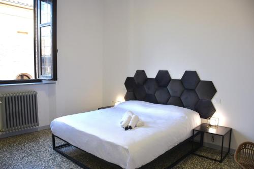 a bedroom with a white bed with a black headboard at Mana Urban Retreat in Ravenna