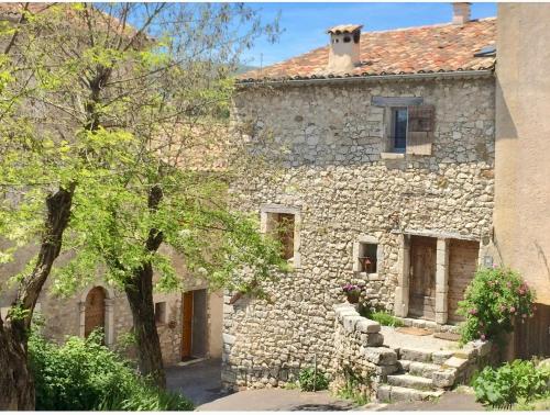 an old stone house with a cat on the roof at LA CALADE in Trigance