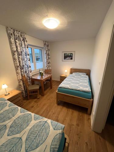 a bedroom with two beds and a table and a desk at Pension / Gaststätte zum Minigolfplatz in Versmold