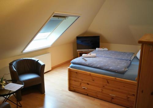 a bedroom with a bed and a window and a chair at Haus Seelotse in Otterndorf bei Cuxhaven in Otterndorf