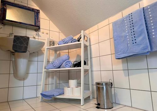 a bathroom with a shelf with towels and a sink at Haus Seelotse in Otterndorf bei Cuxhaven in Otterndorf