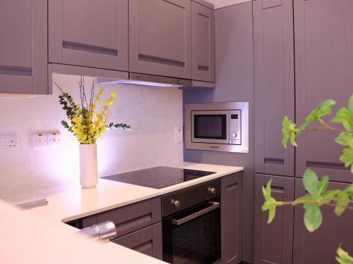 uma cozinha com um vaso com flores amarelas em Spires entire studio em Dublin