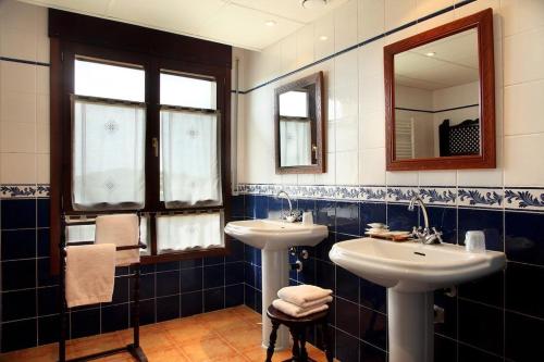 ein Badezimmer mit 2 Waschbecken und einem Spiegel in der Unterkunft Hostería de Guara in Bierge