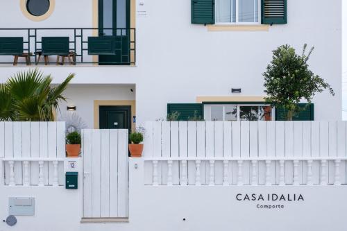 un edificio bianco con una recinzione bianca e piante di Casa Idalia Boutique Hotel a Comporta