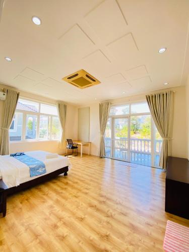 um quarto com uma cama e piso em madeira em SEALINKS VILLA em Ấp Phú Tịnh (2)