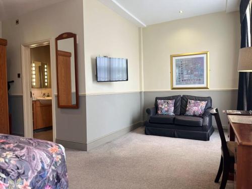 a living room with a couch and a mirror at The Swan Hotel, Stafford, Staffordshire - The Coaching Inn Group in Stafford