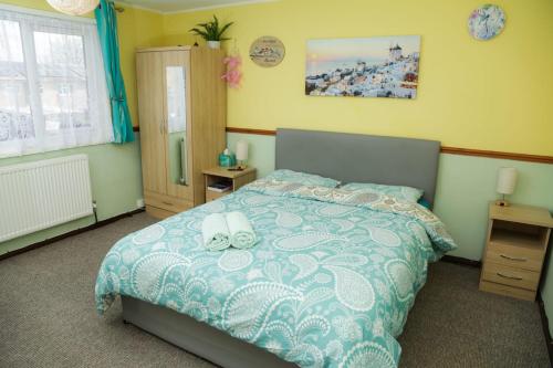 ein Schlafzimmer mit einem Bett mit zwei weißen Handtüchern darauf in der Unterkunft Lux House in Peterborough