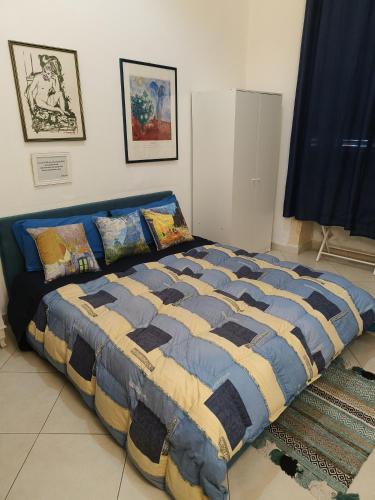 a bedroom with a blue and yellow bed with pillows at B&B IL POETA in Palermo