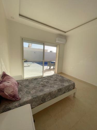 Bett in einem Zimmer mit einem großen Fenster in der Unterkunft Villa Ahmed in Temlale