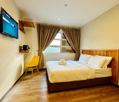 Habitación de hotel con cama y TV en Swing & Pillows - Apple Hotel Shah Alam, en Shah Alam