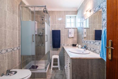 a bathroom with a sink and a shower and a toilet at Villa Glamour by Portucasa in Armação de Pêra