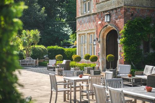 a patio with tables and chairs in front of a building at Burley Manor in Burley