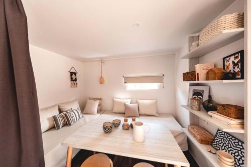 een kleine kamer met een tafel en planken bij Camping La Châtaigneraie in Agos-Vidalos