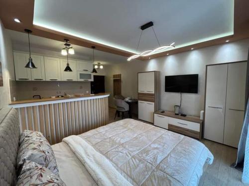 a bedroom with a large bed and a kitchen at ANDREA in Mali Mokri Lug