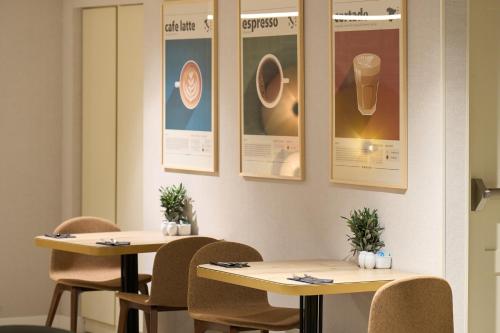 two tables in a restaurant with pictures on the wall at Catalonia Barcelona 505 in Barcelona