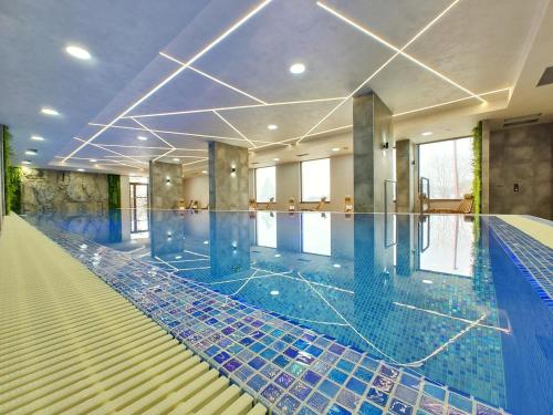 una grande piscina con piastrelle blu sul pavimento di Velika Recepcija CC Magnet a Zlatibor