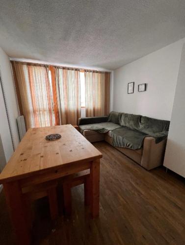sala de estar con sofá y mesa en Modern apartment at the foot of the slopes, en La Plagne Tarentaise