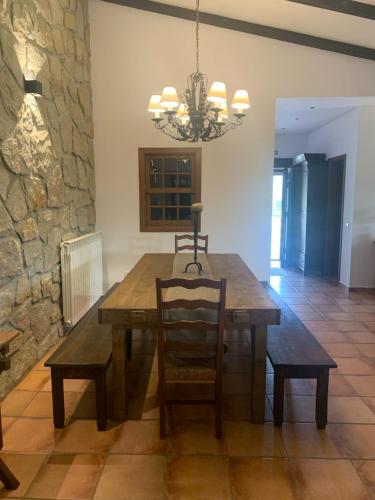 a dining room with a wooden table and a chandelier at Quinta dos Cedros l Turismo Rural in Covilhã