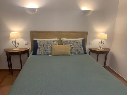 a bedroom with a large bed with two lamps at Quinta dos Cedros l Turismo Rural in Covilhã