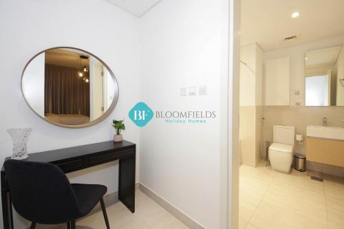 a bathroom with a mirror and a chair and a sink at Brand New Luxury 2 Bedroom Apartment in Abu Dhabi