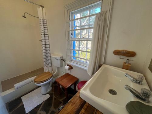 a bathroom with a sink and a toilet and a window at Kom Kyk Cottage in Merweville in Merweville