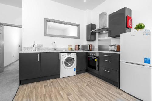 a kitchen with a washing machine and a refrigerator at Modern Apartment in Brierley Hill - Secure Parking - Wifi & Netflix - 11O in Brierley Hill
