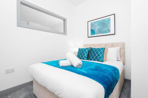 1 dormitorio con 1 cama con sábanas azules y blancas en Modern Apartment in Brierley Hill - Secure Parking - Wifi & Netflix - 11O, en Brierley Hill