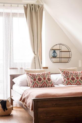 a bedroom with a bed with pillows and a window at Pokoje u Kamińskich 26E in Zakopane