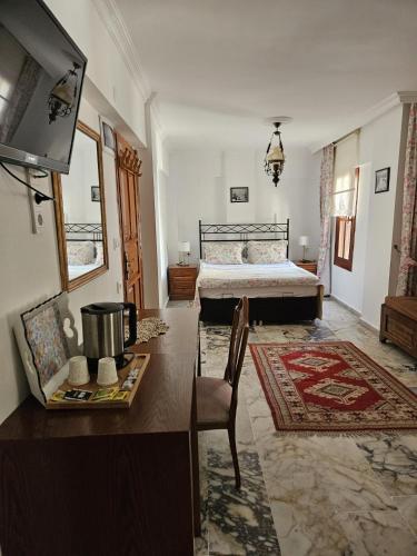 a bedroom with a bed and a table and a television at Sibel Hotel in Antalya