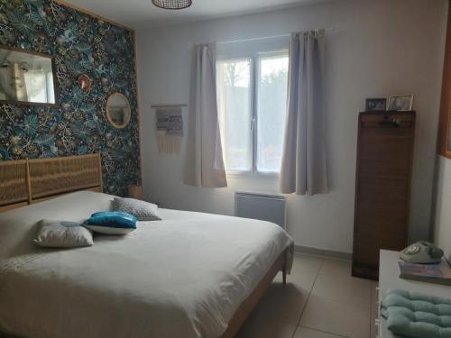 Schlafzimmer mit einem Bett und einem Fenster in der Unterkunft Années 80, enquête et jeux hors du temps in Saint-Romain-le-Preux