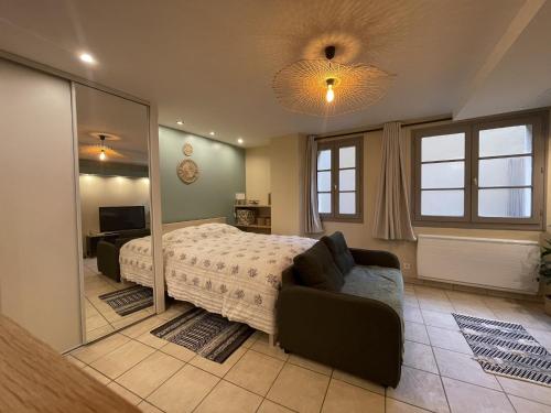 une chambre avec un lit, un canapé et un miroir dans l'établissement Superbe studio centre Limoges, à Limoges