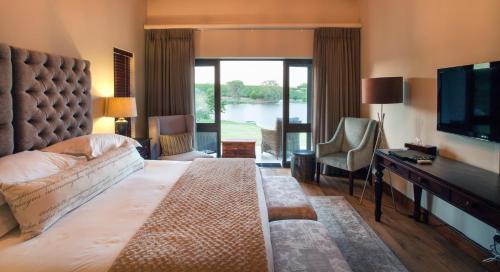 a hotel room with a large bed and a television at Under Oaks Guesthouse in Paarl