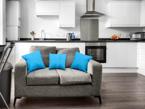 un sofá en una cocina con almohadas azules en Hamish Apartment en Stirling