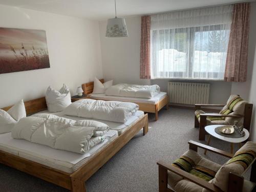 Habitación con 2 camas, sofá y mesa. en Ferienwohnung in Philippsreut mit Terrasse, Garten und Grill en Philippsreut