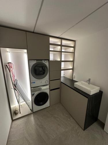 a kitchen with a washer and a sink and a refrigerator at Luxury Villa Cloer, Jadranovo - Sauna,Steam room, 2 Jacuzzis in Jadranovo