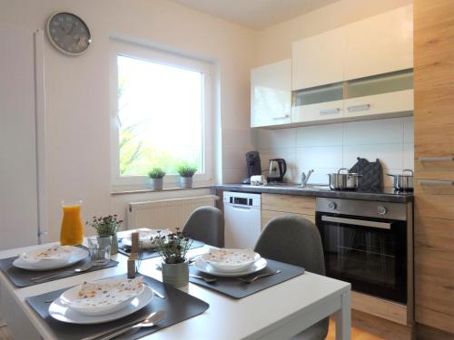 a kitchen with a table and a dining room at Helles Apartment mit Balkon für 5 Personen in Schwerte