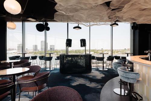 a restaurant with tables and chairs and large windows at DoubleTree by Hilton Amsterdam Centraal Station in Amsterdam