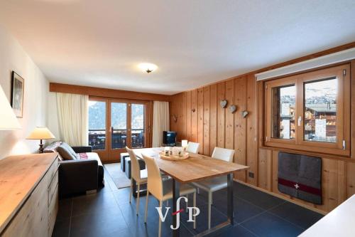 uma sala de estar com uma mesa e um sofá em Fauvettes 110 em Verbier