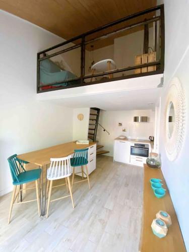 une cuisine avec une table et des chaises dans une pièce dans l'établissement Maison de vacances proche plage des Sables d'Olonne, à La Pironnière