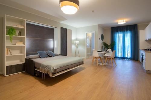 a bedroom with a bed and a table and a kitchen at Itinera Home Residence in Montalto Uffugo