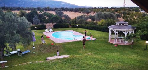 a group of people playing in the grass by a pool at Farmhouse with pool minutes from beach in Amarinthos
