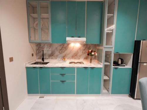 a kitchen with blue cabinets and a sink at شقق همس بارك للشقق المخدومة in Jeddah