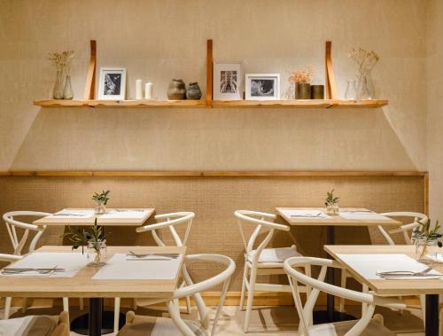 a dining room with tables and chairs and shelves at Musik Boutique Hotel in Barcelona